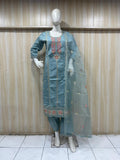 mannequin waering a teal embroidered outfit with asheer dupatta against a wooden panel bagaraond
