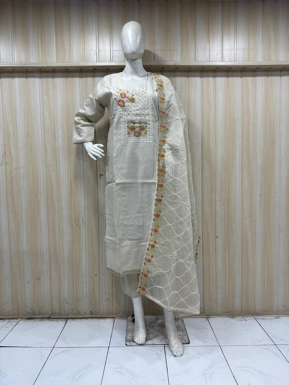 mannequin waering a embroidered traditional outfit with floral dupatta against a striped wall