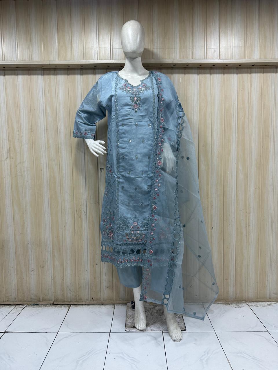 mannequin waering a blue embroidered traditional outfit with a sheer dupatta against a wooden panel bacgraound