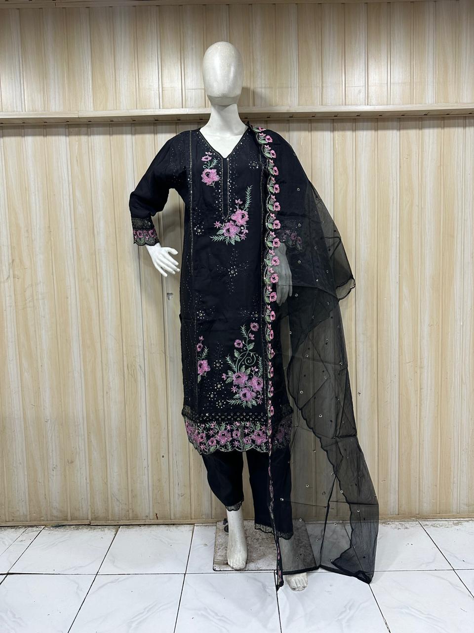 black embroidered traditional  with pink flowers mannequin against a striped wall