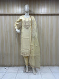 mannequin waering a light green embroidered outfit against a wooden panel background
