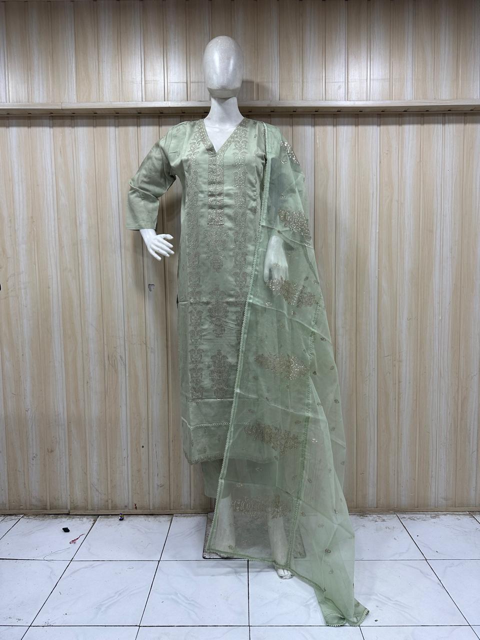green traditional outfit on a mannequin against a striped wall