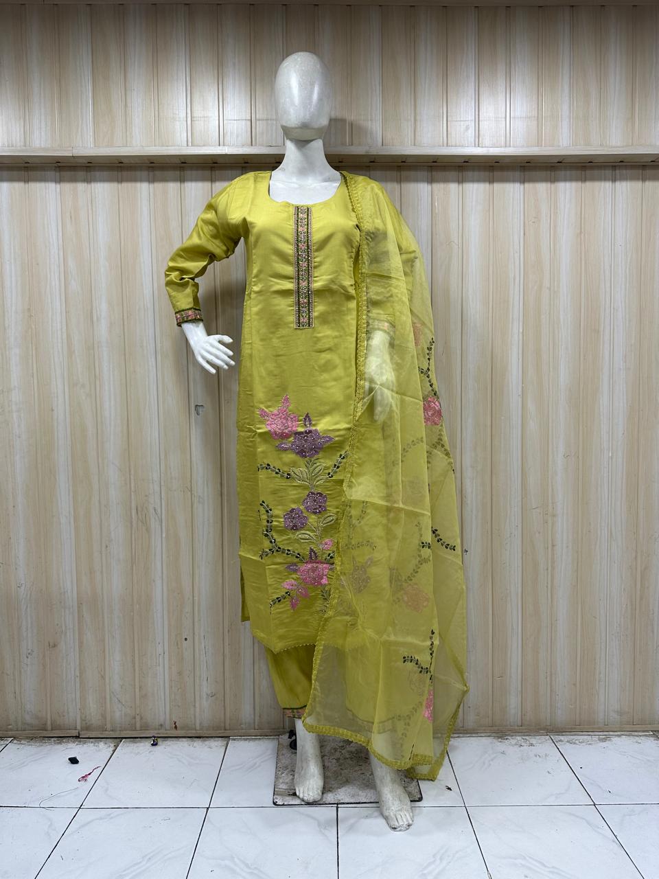 mannequin waering a green kurta with floral embroidered  against a striped wall