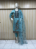 mannequin waering sky blue embroidered black  outfit against a striped wall
