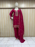 mannequin waering a teal embroidered outfit with a sheer dupatta against a wooden panel