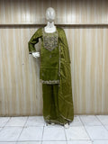 green treditional outfith with  embroidered on a mannequin against a striped wall