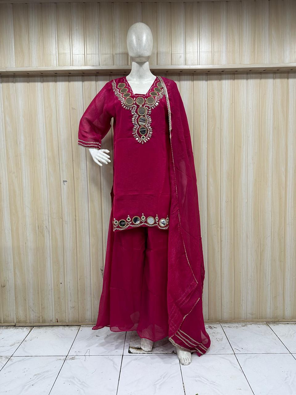 maroon treditional outfith with intricate design on a mannequin against a striped wall