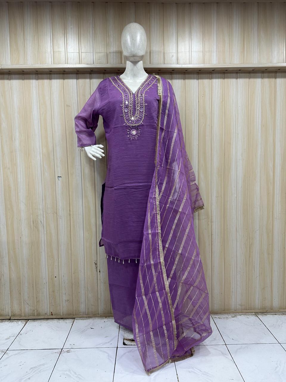 purple treditional outfith with a dupatta on a mannequin against a striped wall