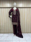 maroon embroidered treditional outfith on a mannequin against a striped wall