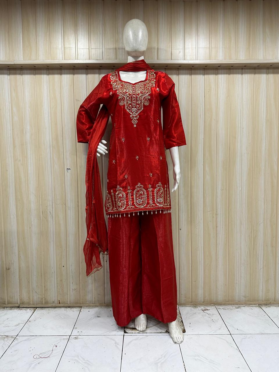 red embroidered treditional on a mannequin against a striped wall