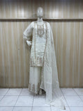 white embroidered treditional on a mannequin against a striped wall