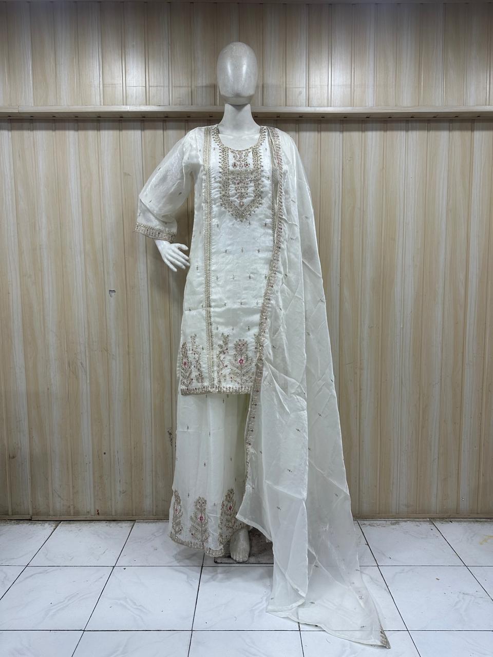 white embroidered treditional on a mannequin against a striped wall
