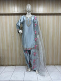 mannequin weaering a lite blue embroidered outfit with a pink floral patterns against a striped wall