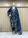 mannequin weaering a nave blue embroidered outfit against a wooden panel background