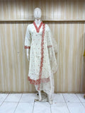 white embroidered traditional on a mannequin against a striped wall