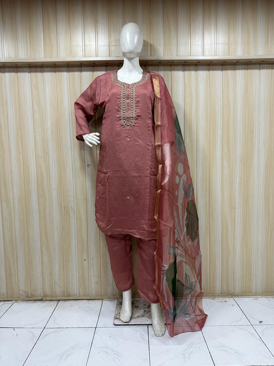 maroon traditional outfit with embroiered detials on a mannequin against a striped wall