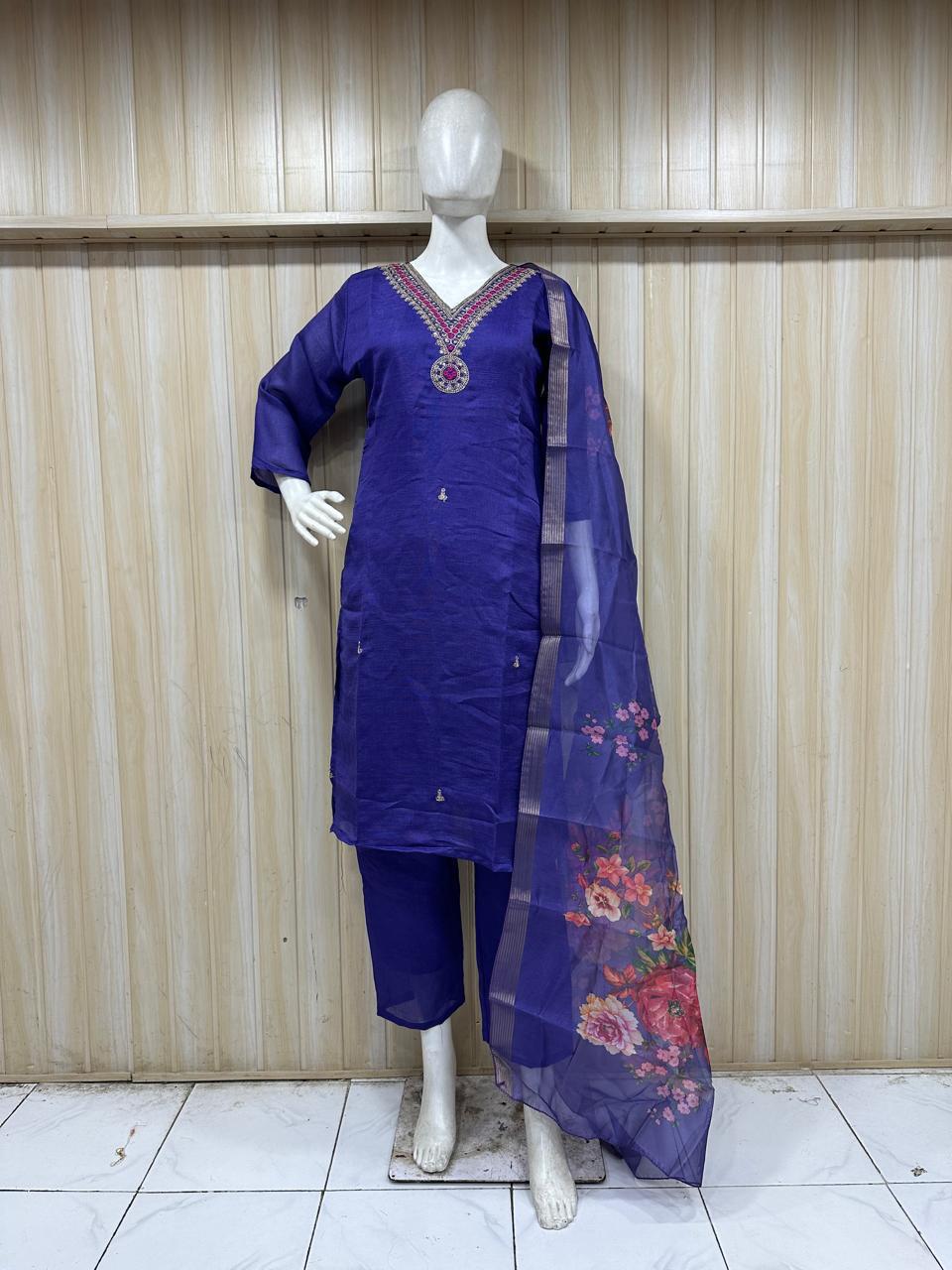 mannequin wearing a purpal traditional outfit with embroiered a floral dupatta against a striped wall