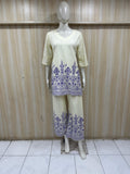 mannequin wearing a traditional cream kurta with a floral against a striped wall