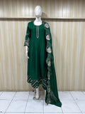 mannequin wearing green traditional dress outfit white embroidered against a striped wall