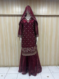mannequin wearing green traditional dress outfit white embroidered against a striped wall