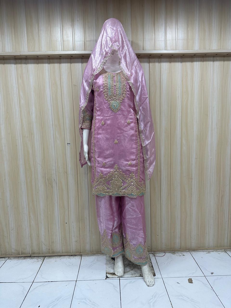 mannequin wearing pink traditional dress outfit against a striped wall