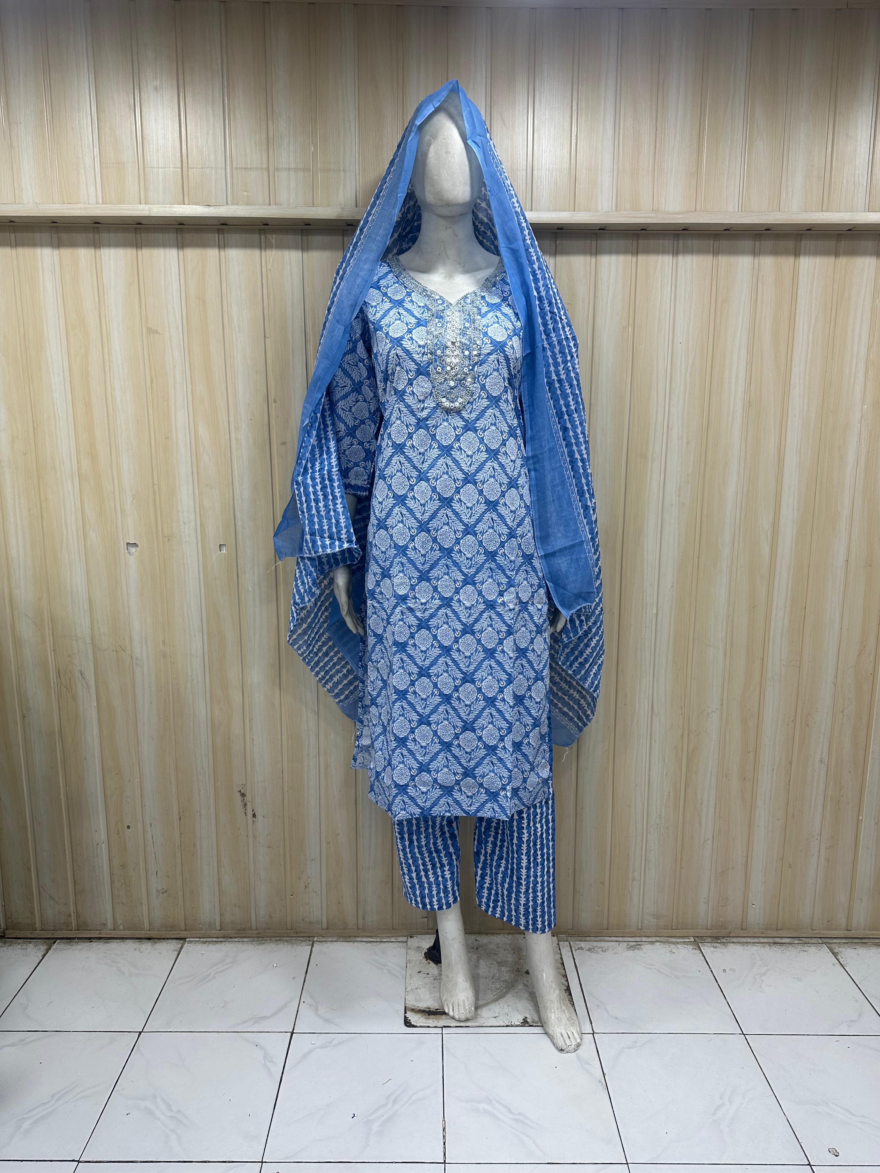mannequin wearing patterned bluetraditional outfit with a matching dupatta against a striped wall