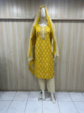 mannequin wearing patterned yellow traditional outfit with a matching dupatta against a striped wall