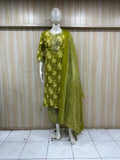mannequin wearing a green floral outfit with a matching dupatta shawl headscraf against a striped wall