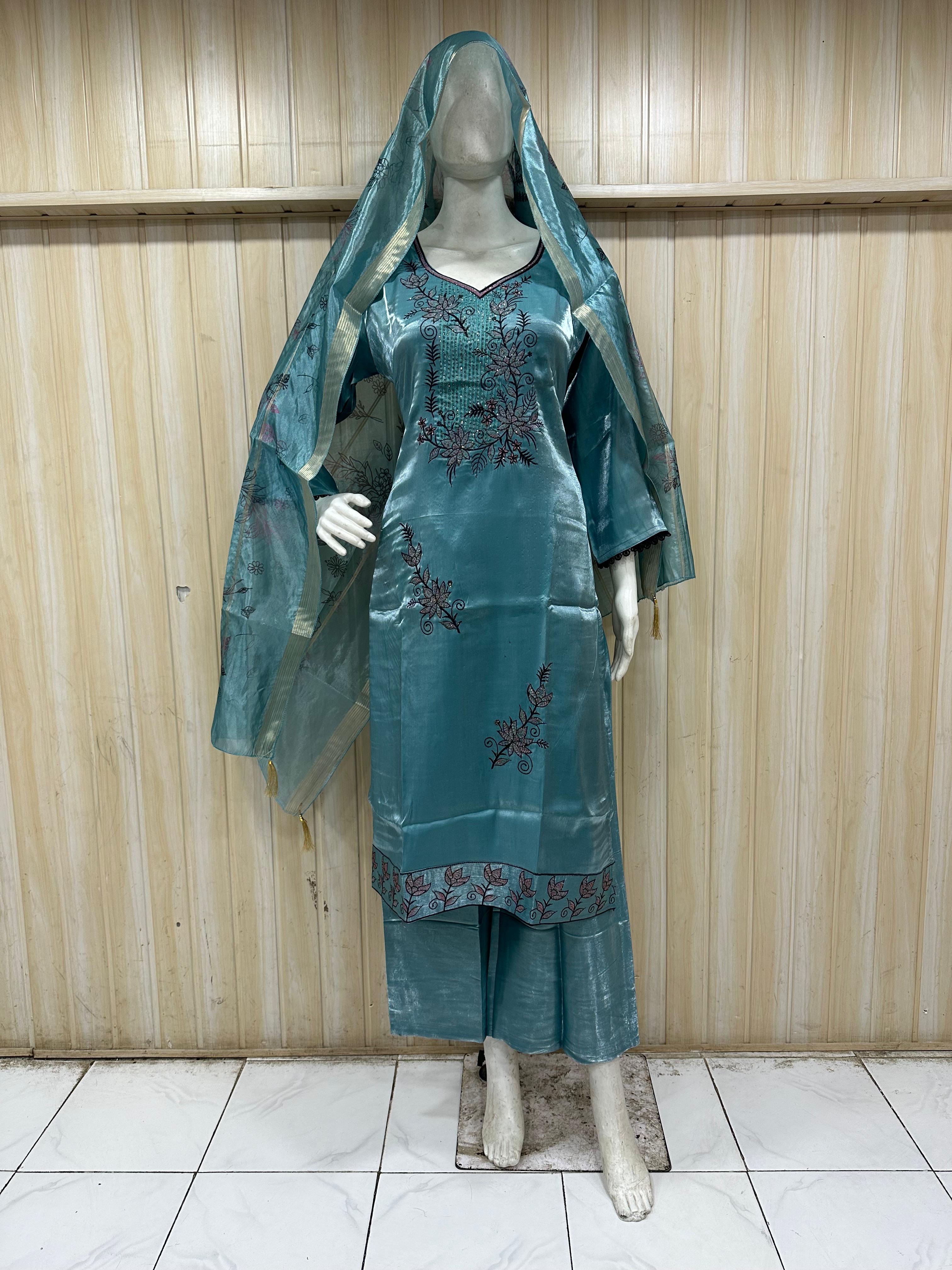 mannequin wearing a tea embroidered floral outfit with a matching dupatta against a wooden panel backgruond  ChatGPT6:38 PM