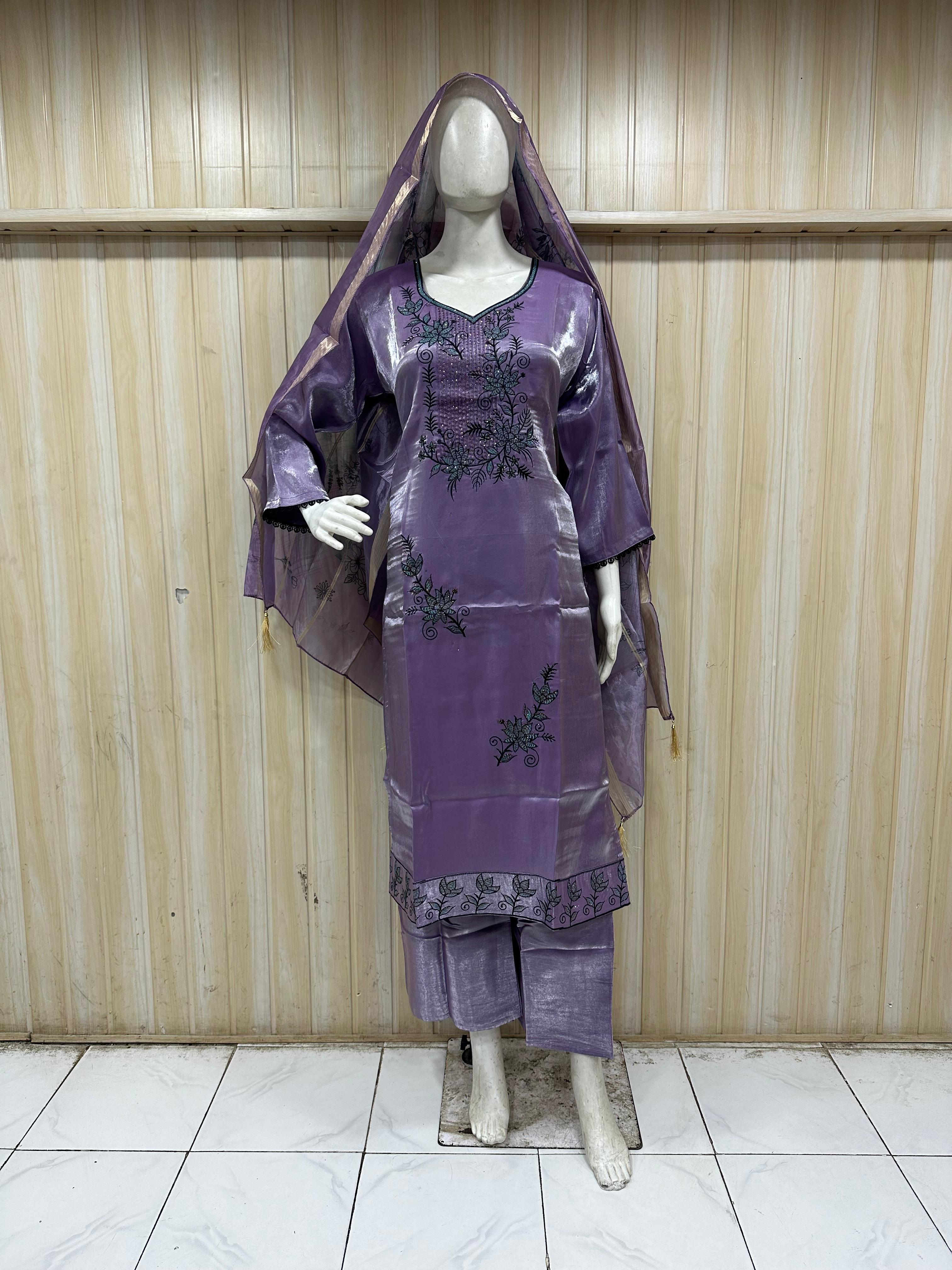 mannequin wearing a purpal embroidered floral outfit with a matching dupatta against a wooden panel backgruond