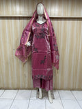mannequin wearing a red embroidered floral outfit with a matching dupatta against a wooden panel backgruond