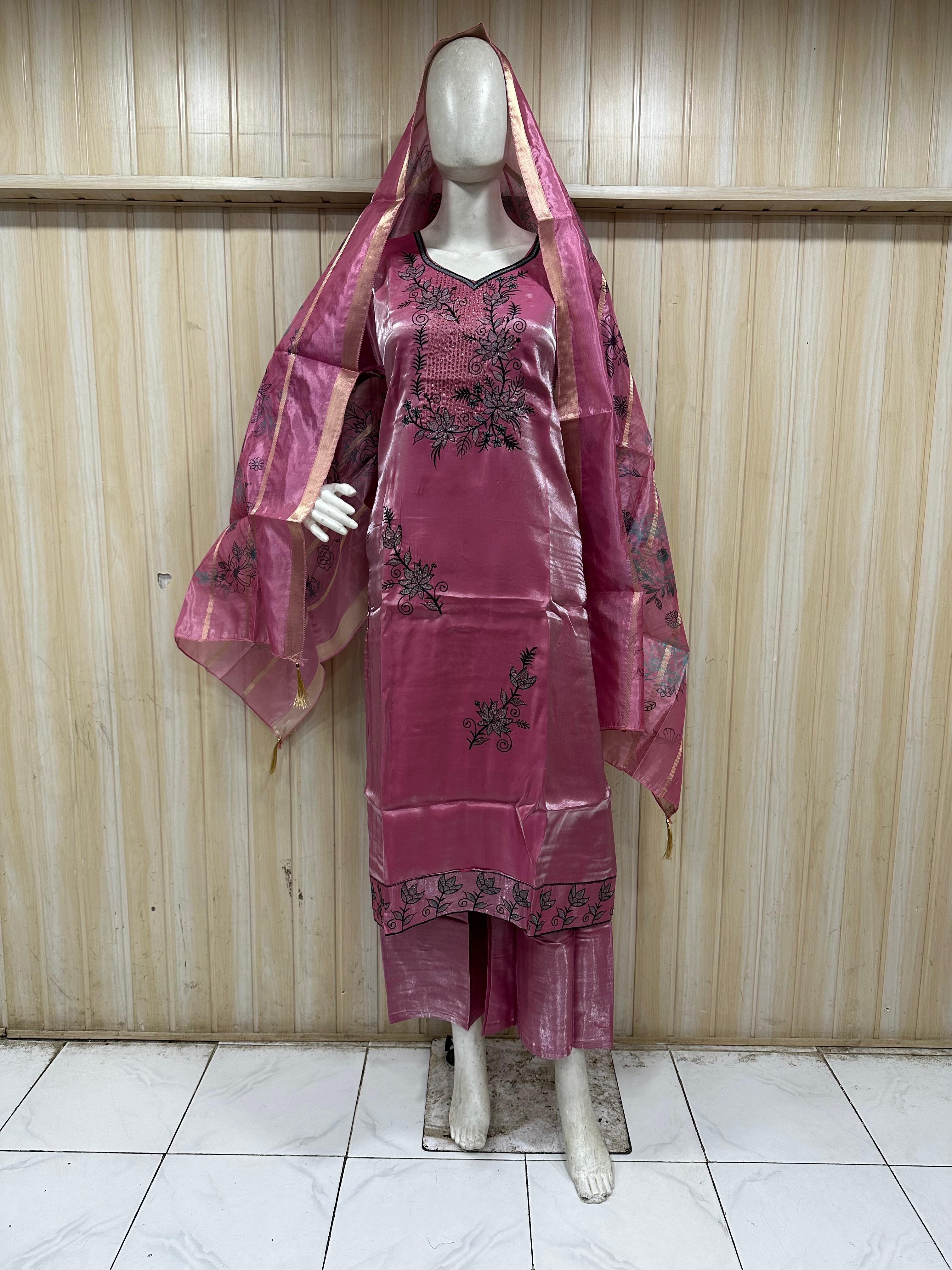 mannequin wearing a red embroidered floral outfit with a matching dupatta against a wooden panel backgruond