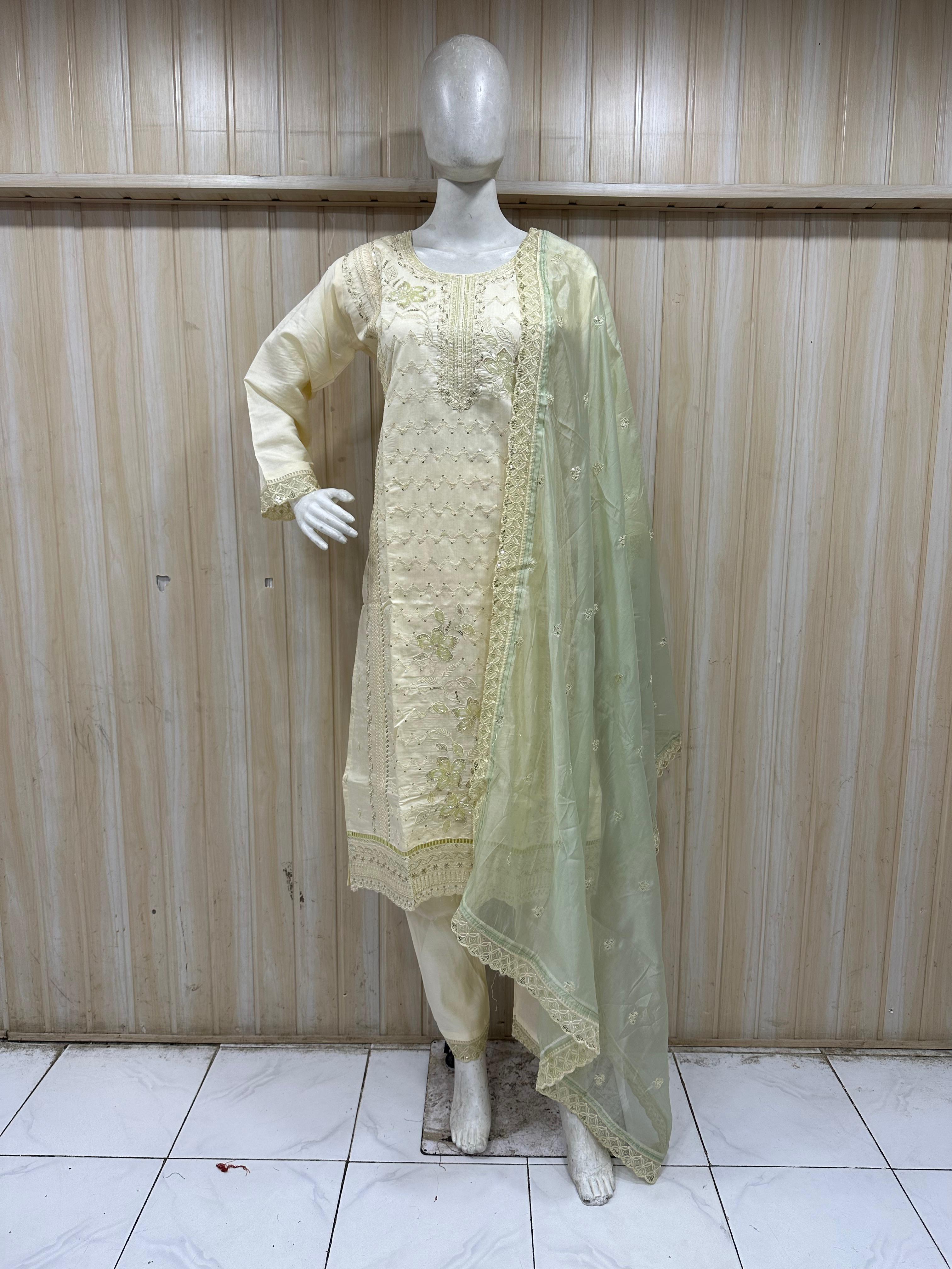 mannequin wearing a light green embroidered floral outfit with a matching dupatta dupatta against a striped wallPink Designer Embroidered Floral Traditional Kurti Set with Yellow Dupatta