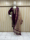 mannequin wearing a purpal traditional floral outfit with a matching dupatta shawl headscraf against a wooden panel