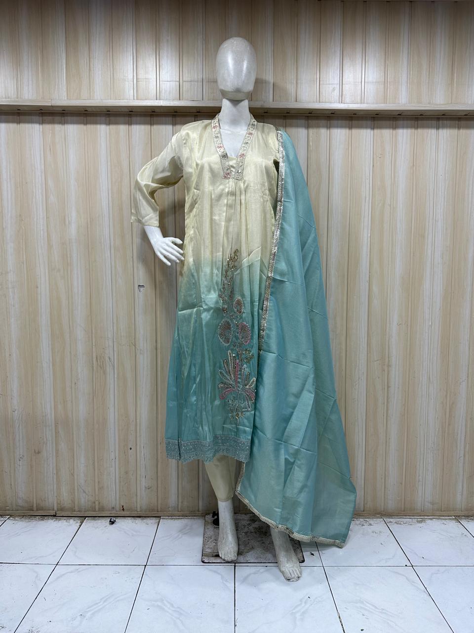 mannequin wearing a sky blue traditional floral outfit with a matching dupatta shawl headscraf against a wooden panel