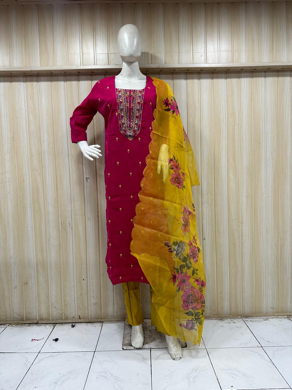 mannequin wearing a red with white embroidered outfit with yallow dupatta Floral Traditional against astriped wall