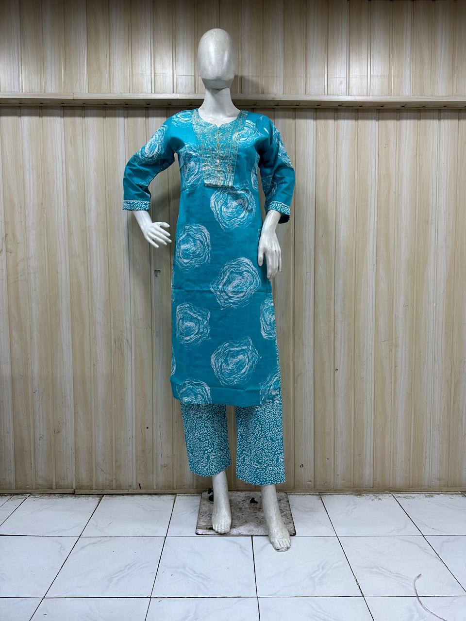 mannequin wearing a sky blue outfit with Floral Traditional against a wooden panel background