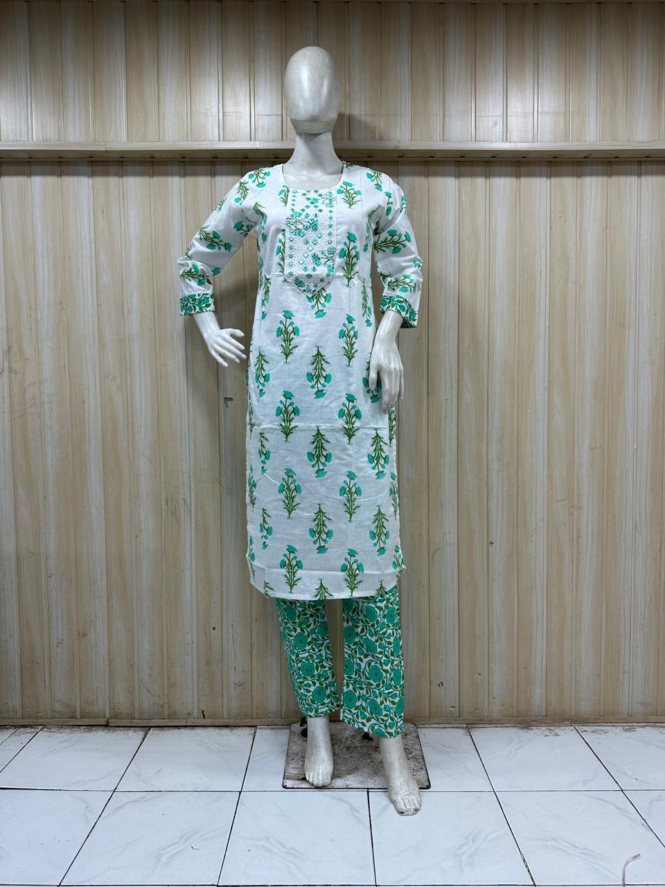 mannequin wearing a white and green outfit with dress Floral dress Traditional against a wooden panel background