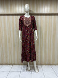 mannequin wearing a maroon floral dress outfit with Traditional against a wooden panel background
