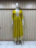 mannequin wearing a green floral dress outfit with Traditional against a wooden panel background