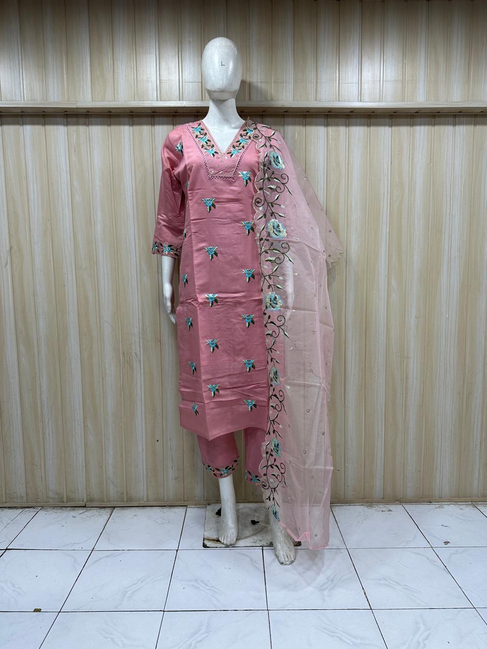 Mannequin wearing a pink embroidered outfit with a matching dupatta against a striped