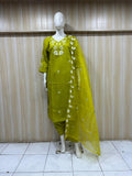 Mannequin wearing a green traditional outfit with white floral embroidery against a striped