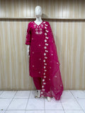 Mannequin wearing a magenta traditional outfit with white floral patterns against a striped