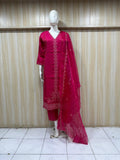 Mannequin wearing a red embroidered outfit against a striped
