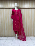 traditional red outfit with pink and embroidery on a mannequin against a striped