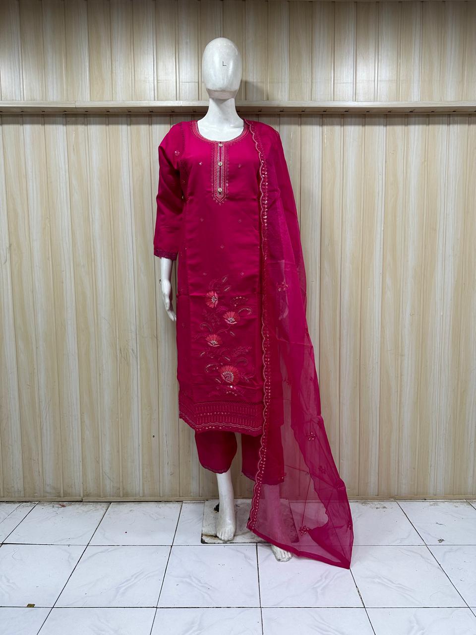 traditional red outfit with pink and embroidery on a mannequin against a striped