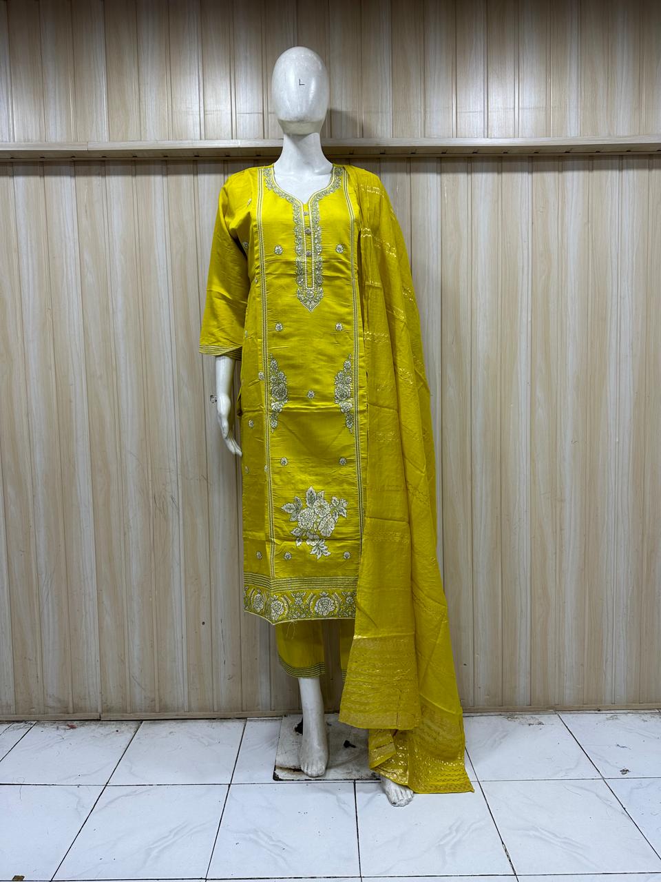 Yellow traditional outfit on a mannequin against a striped wall.