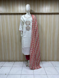 White kurta with red and gold embroidery paired with a red and gold dupatta on a mannequin against a striped