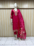 Red embroidered traditional outfit on a mannequin against a striped