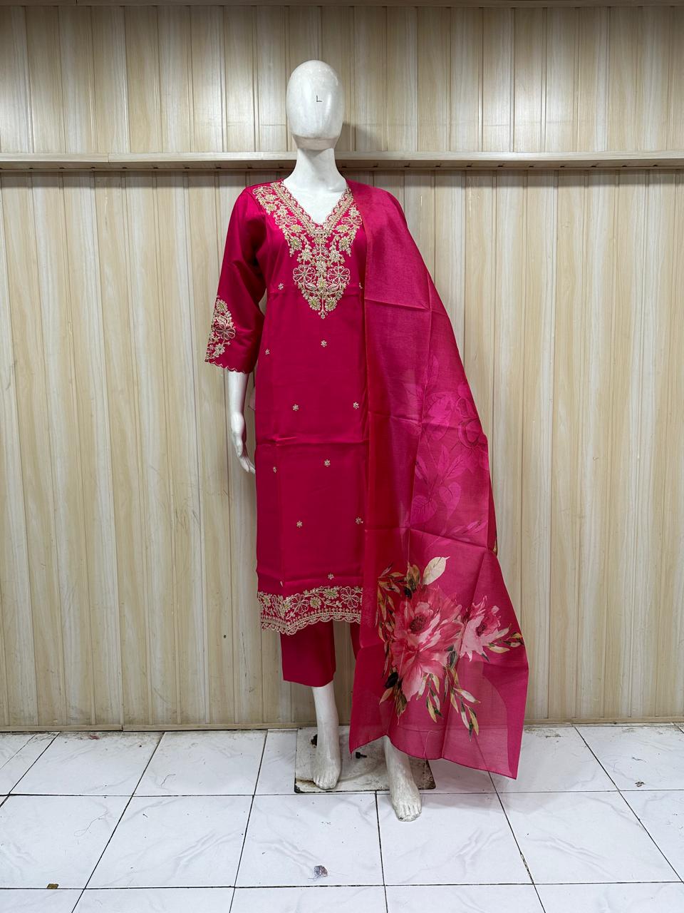 Red embroidered traditional outfit on a mannequin against a striped